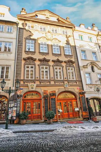 Historic Prague building with carved details and twin red doors