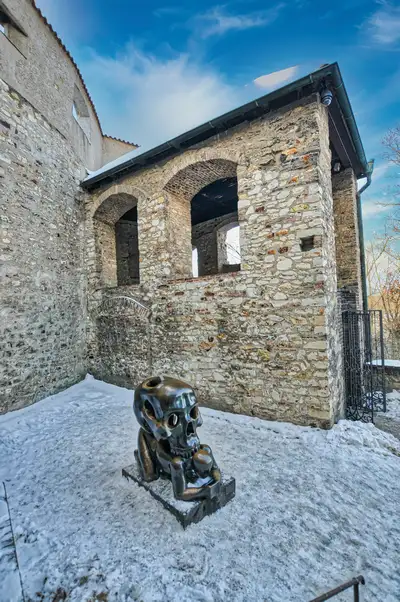 Bronze skull sculpture in a stone courtyard in Prague
