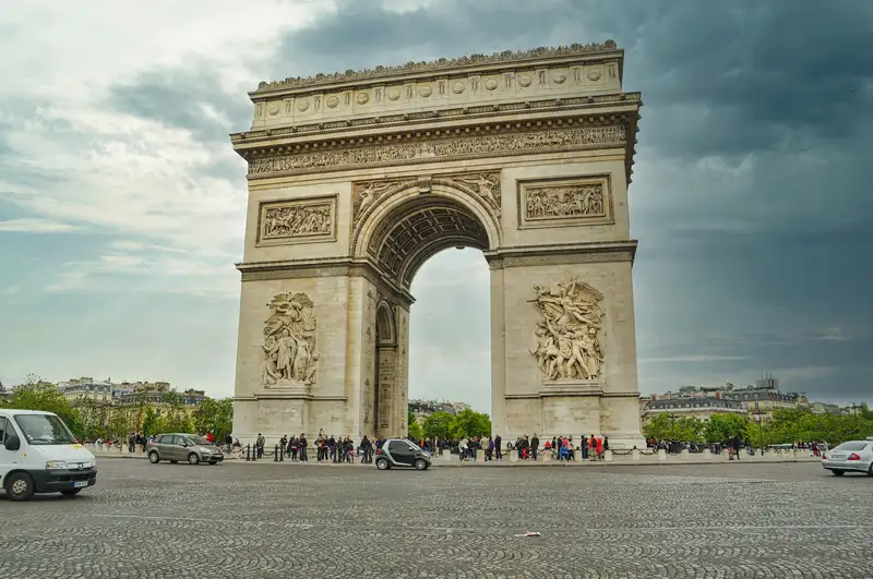 The Arc de Triomphe standing over its wide square at the top of the Champs-Élysées in Paris