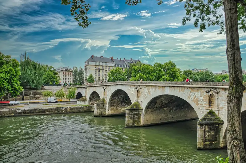An old stone bridge with arches crossing the Seine in Paris