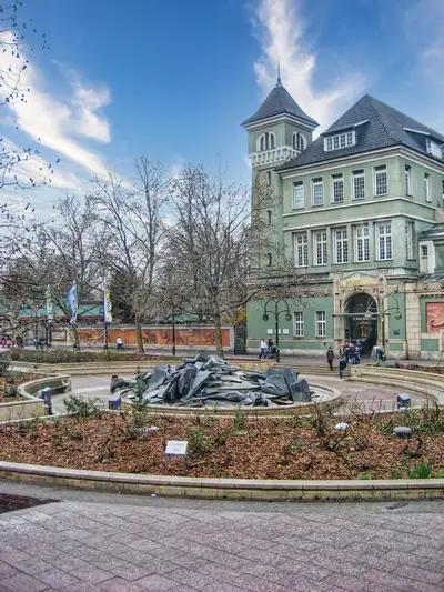 Historic green building and a fountain near the entrance to Berlin Zoo