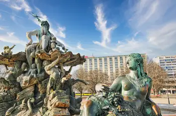 The Neptune Fountain with its bronze sea figures in central Berlin, Germany, with city buildings behind