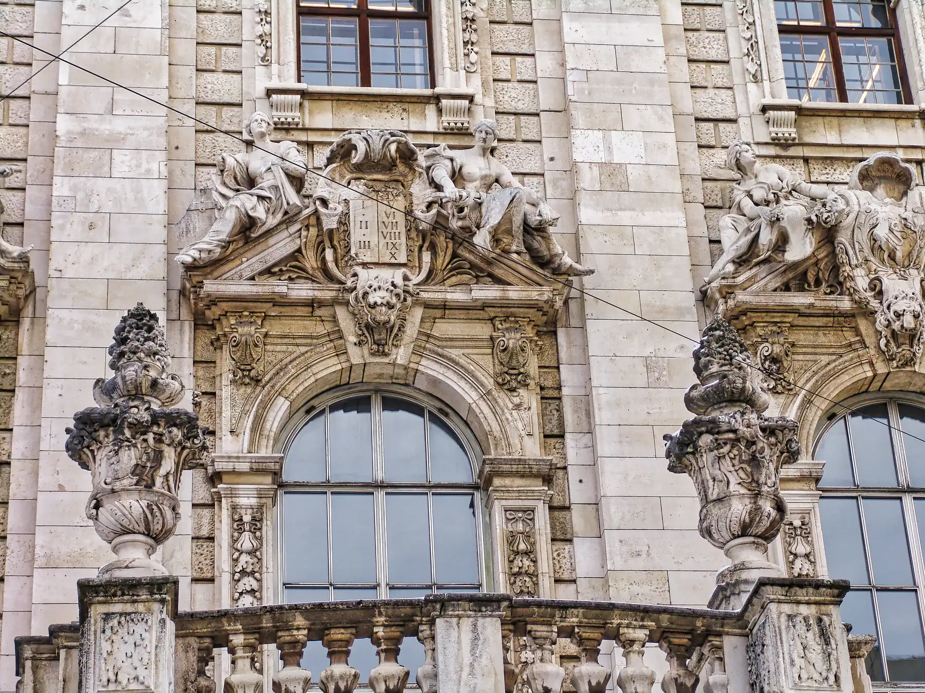 Ornate baroque facade with carved statues and arched windows on a historic building in Munich, Germany