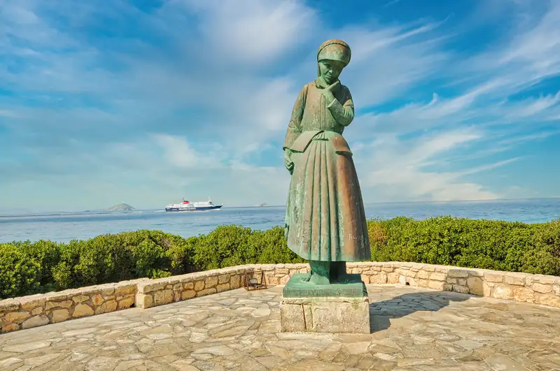 Bronze sculpture of a standing female figure at the Kapralos Museum in Aegina with a ferry crossing the Saronic Gulf visible in the background