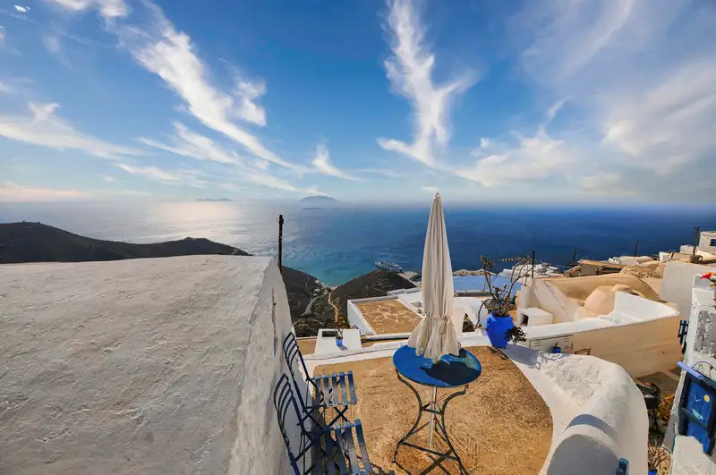 Anafi Chora terrace with a blue table and panoramic views of the Aegean Sea and distant islands