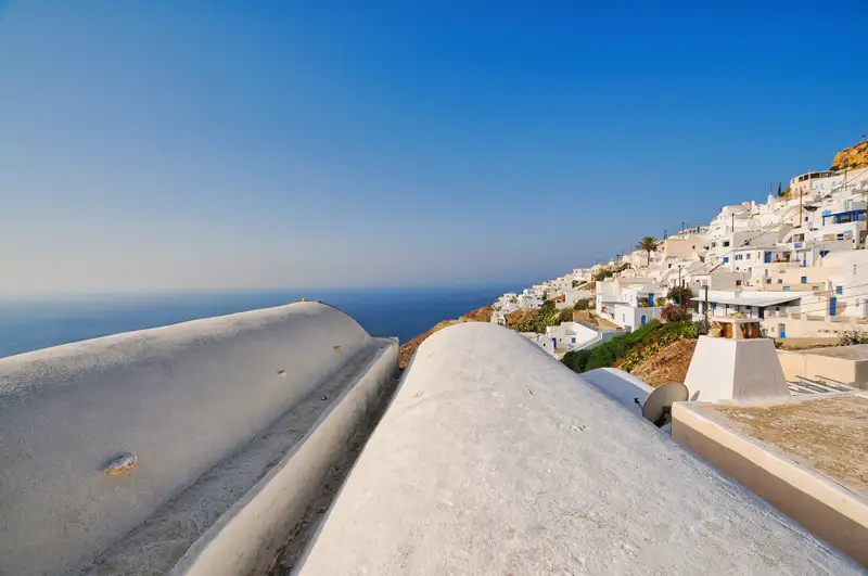 Whitewashed rooftops of Anafi Chora cascading down the hillside toward the deep blue Aegean