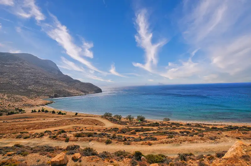 Monastiri beach in Anafi with a curved bay, turquoise waters, and golden hills framing the shore