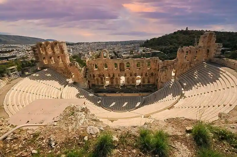 Aerial view of the Odeon of Herodes Atticus on the slope of the Acropolis hill showing the semicircular stone seating and stage area with Athens spreading out behind it