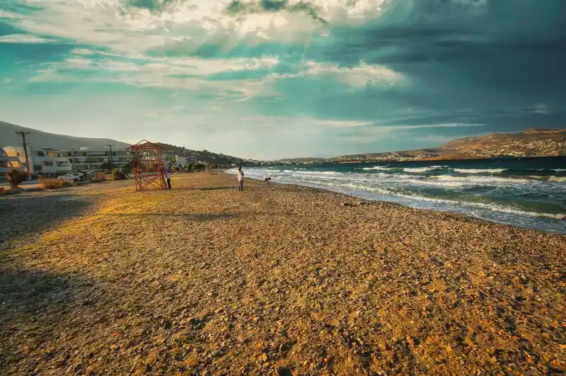 Avlaki beach in Porto Rafti with pebbled shore, lifeguard tower, and waves rolling onto the eastern Attic coast