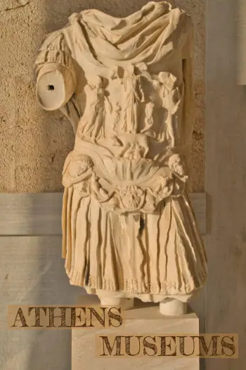 Ancient marble statue torso with detailed relief carvings displayed in an Athens museum