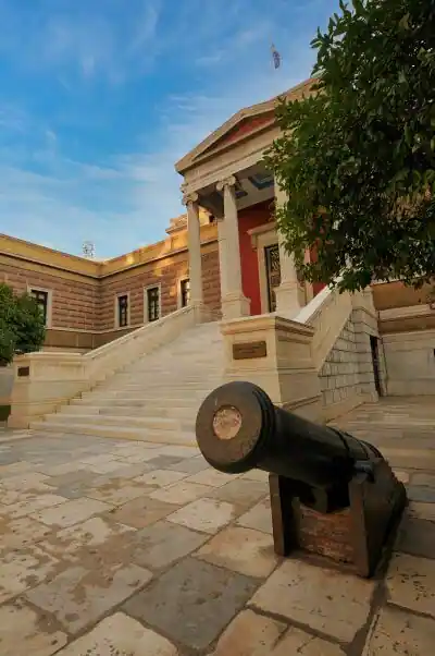 A cannon from the Greek War of Independence in front of the National Historical Museum in Athens with the neoclassical Old Parliament Building in the background