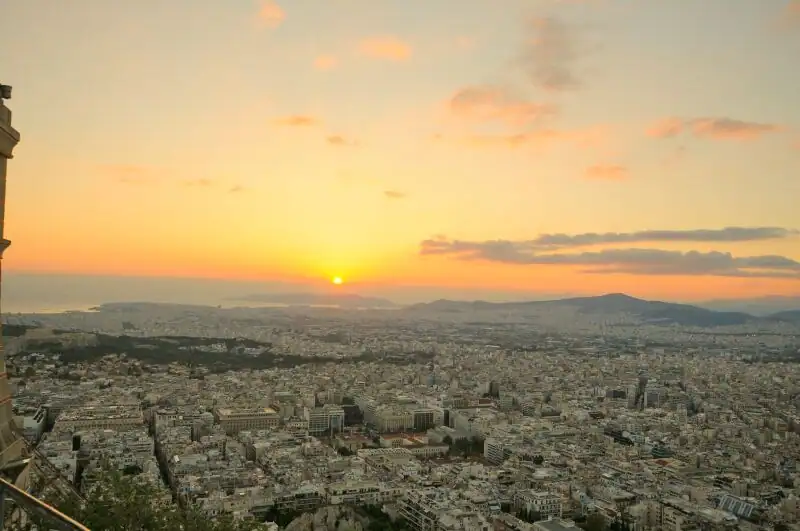 Golden sunset over Athens seen from Lycabettus Hill with the sun dropping toward the Saronic Gulf