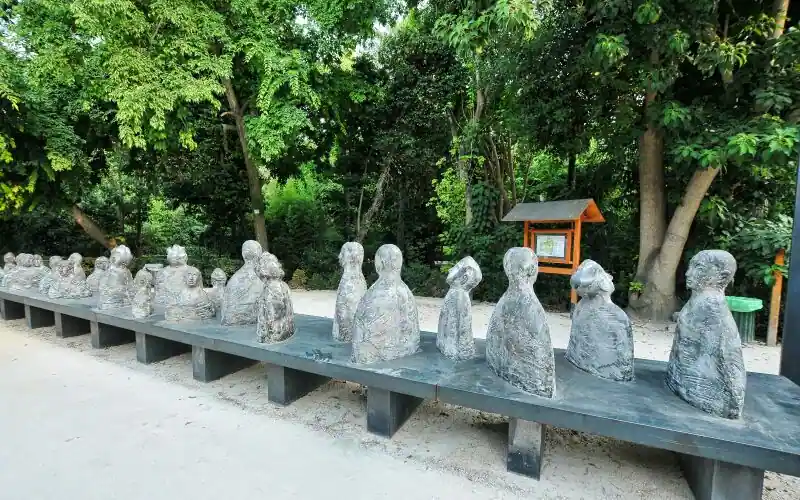 Modern art sculpture of seated figures on a metal bench inside the National Garden in Athens