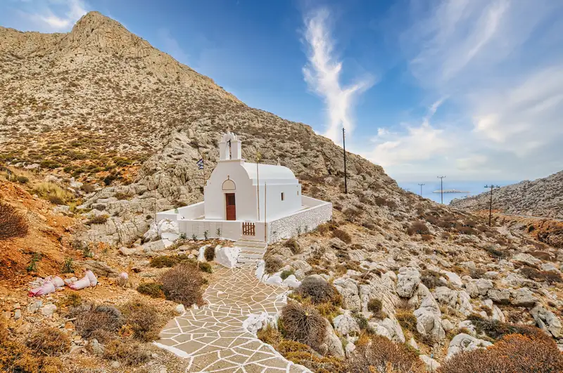 Whitewashed chapel in Folegandros set against a rocky hillside