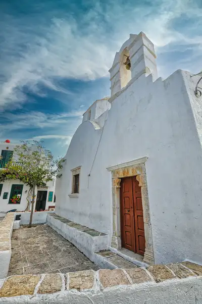 Traditional church in Chora Folegandros with white walls and a stone bell tower