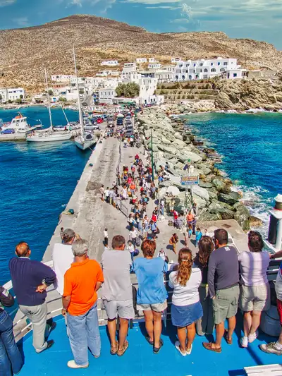 Karavostasis port from the ship with passengers walking along the pier in Folegandros