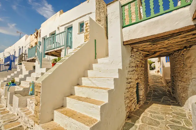 Traditional Kastro residences in Folegandros with white stairs and stone archway