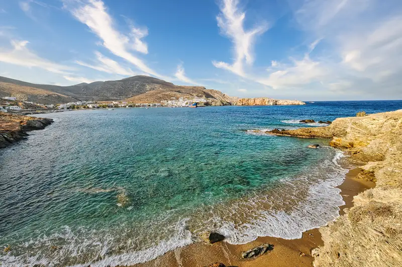 Latinaki beach in Folegandros with clear water, golden sand, and rocky shoreline