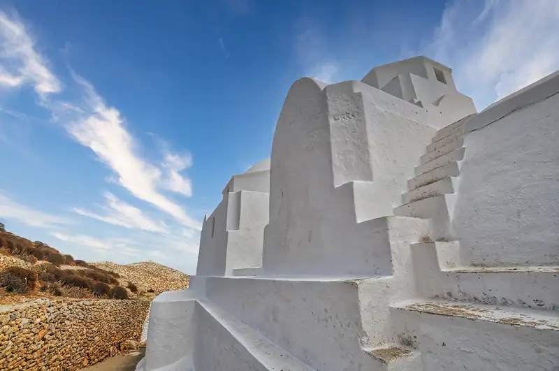Panagia church folegandros with white walls and stone terraces above the village
