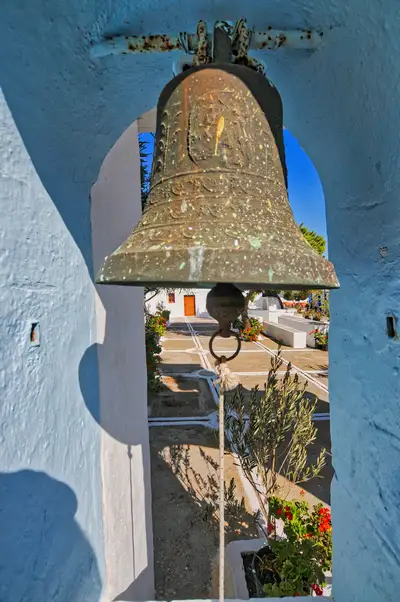 Traditional church in Chora Folegandros with white walls and a stone bell tower