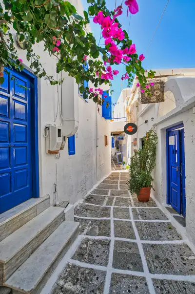 Narrow pathway in Chora Folegandros with whitewashed walls and stone paving