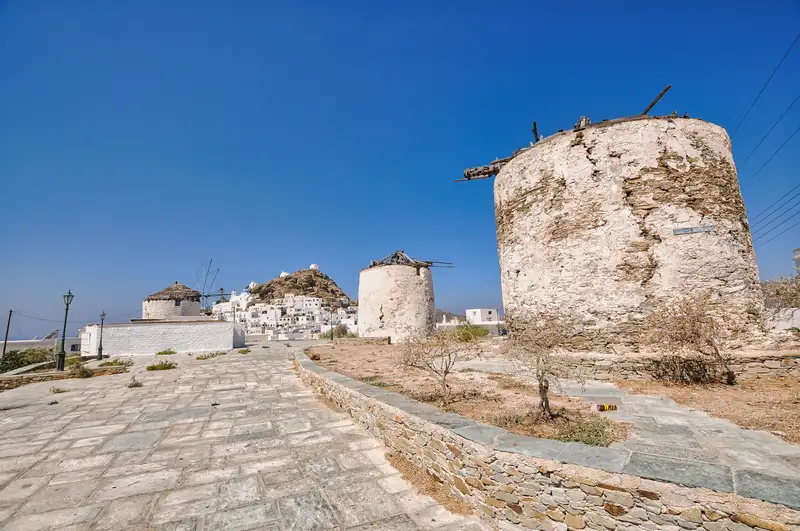 The old stone windmills above Chora on Ios, with the village climbing behind them