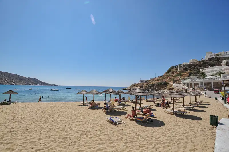 Sun beds and thatched umbrellas on Gialos beach in Ios