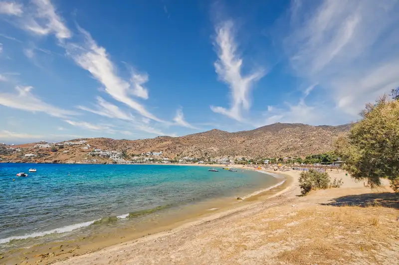 The wide curve of Mylopotas beach on Ios island, with golden sand and turquoise water