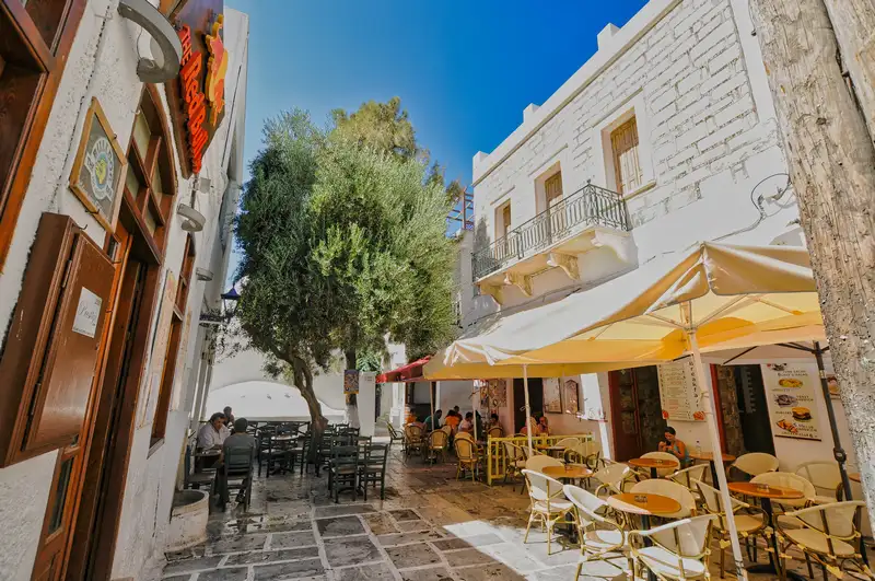 A lively square in Chora of Ios with restaurants, tables, and outdoor seating