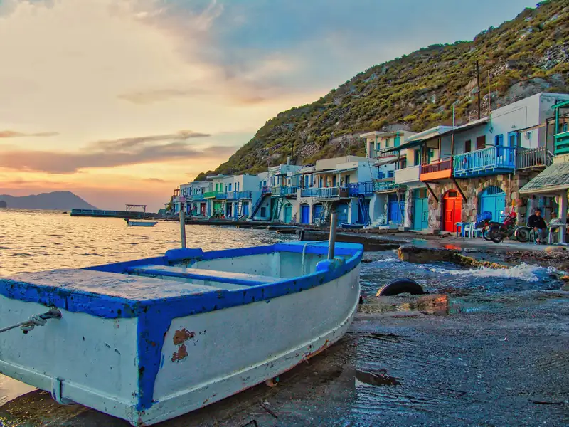 A small fishing boat resting in front of the syrmata houses of Klima at dusk