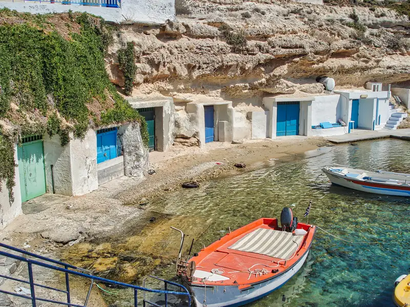 Traditional syrmata boat houses carved into the rock at the small harbor of Mandrakia on Milos island