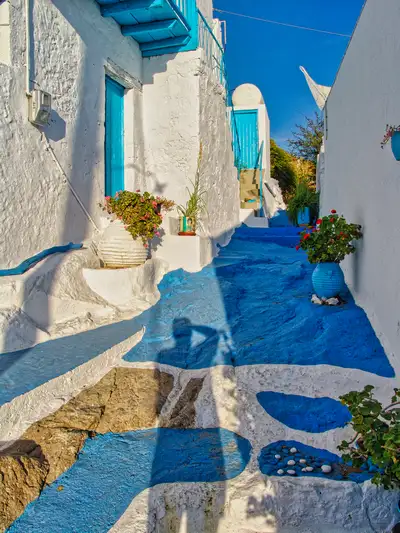 A traditional alley in Plaka village with hand-painted blue and white stones on the floor and whitewashed walls