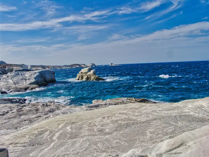 The white volcanic rocks of Sarakiniko beach meeting the deep blue Aegean Sea
