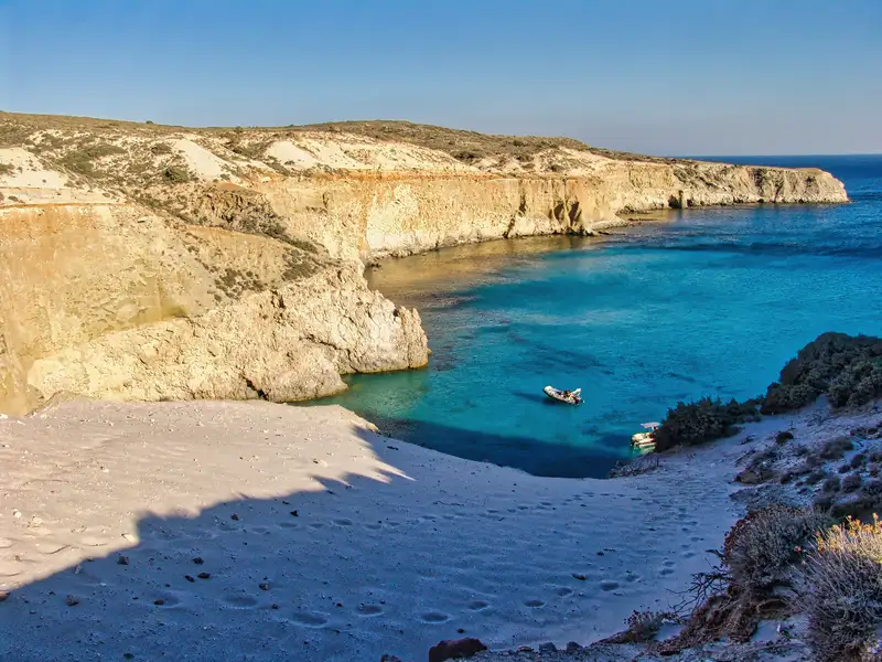 A hidden cove with turquoise water and white sand at Tsigrado beach on the south coast of Milos island