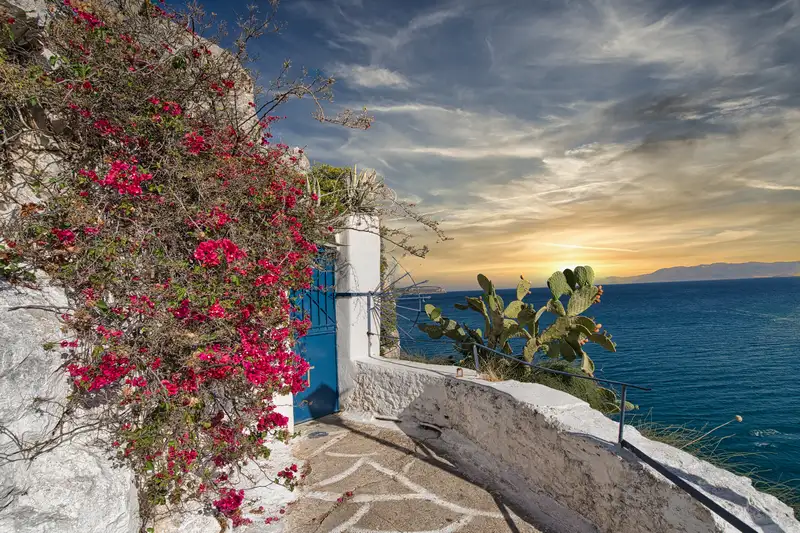 Stone path along the cliffs of Nafplio with bougainvillea and the Argolic Gulf