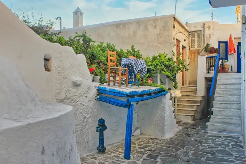 Whitewashed alleyway with blue details inside Chora Naxos