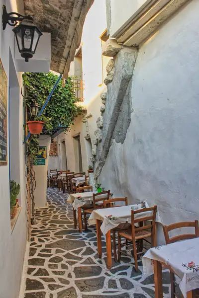Narrow taverna alley with cobblestones in Chora Naxos Town