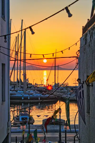Naxos sunset over the harbour seen through an alley in Chora