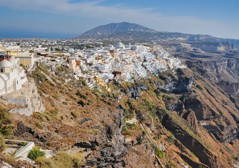 The town of Fira in Santorini above the volcanic slopes, with the mountain in the distance