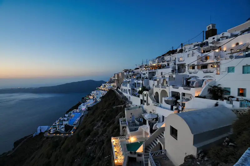 Imerovigli village lit up at dusk on the Santorini caldera