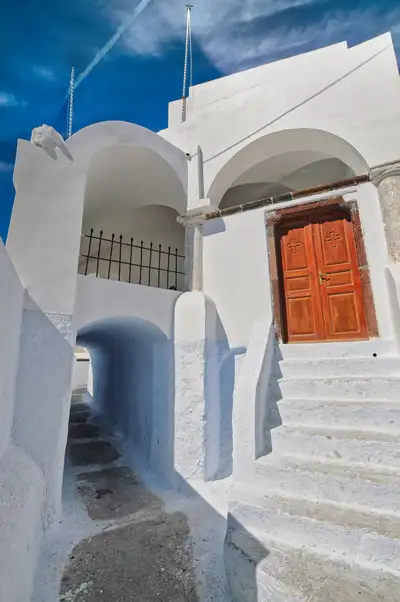 A shaded archway and old doorway in the quiet lanes of Pyrgos, Santorini