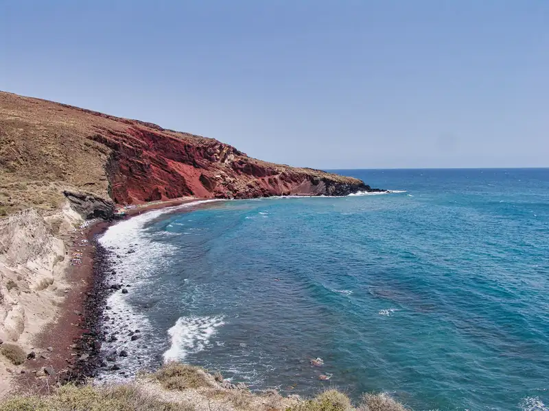 The famous Red Beach of Santorini set against red and ochre rock
