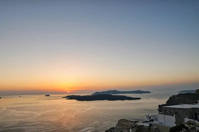 Sunset over the Santorini caldera and volcano islands seen from the Fira cliffs