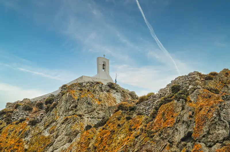Whitewashed chapel with a bell tower on a rocky outcrop in Serifos