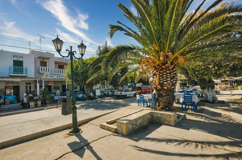 Palm tree and taverna tables along the waterfront street of Livadi