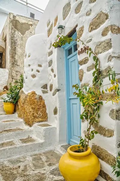 Traditional Cycladic doorway framed by climbing greenery and pottery, Serifos