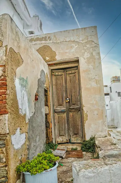 Faded plaster and an old timber doorway in the alleys of Chora, Serifos
