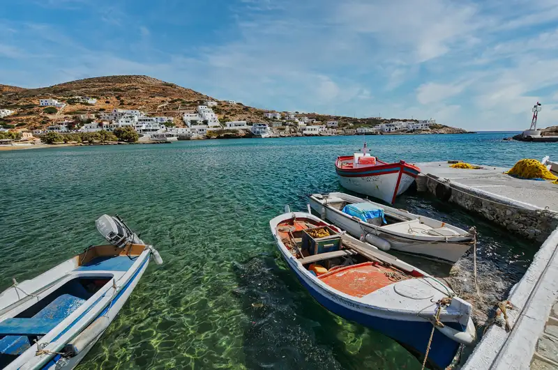 Fishing boats moored at Alopronia port with the village of Sikinos behind