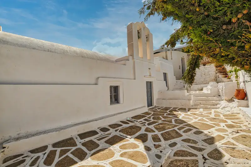 Cycladic church with belfry and paved courtyard in the village of Chora