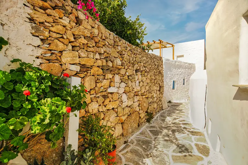 Whitewashed lane lined with flowers in the village of Chora on Sikinos